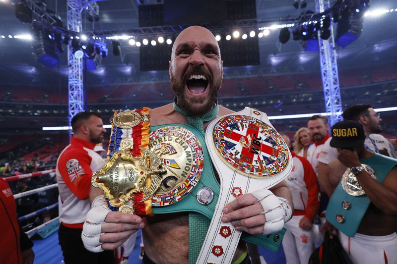 Boxing - Tyson Fury v Dillian Whyte - WBC World Heavyweight Title - Wembley Stadium, London, Britain - April 23, 2022  Tyson Fury celebrates with the belts after winning his fight against Dillian Whyte Action Images via Reuters/Andrew Couldridge