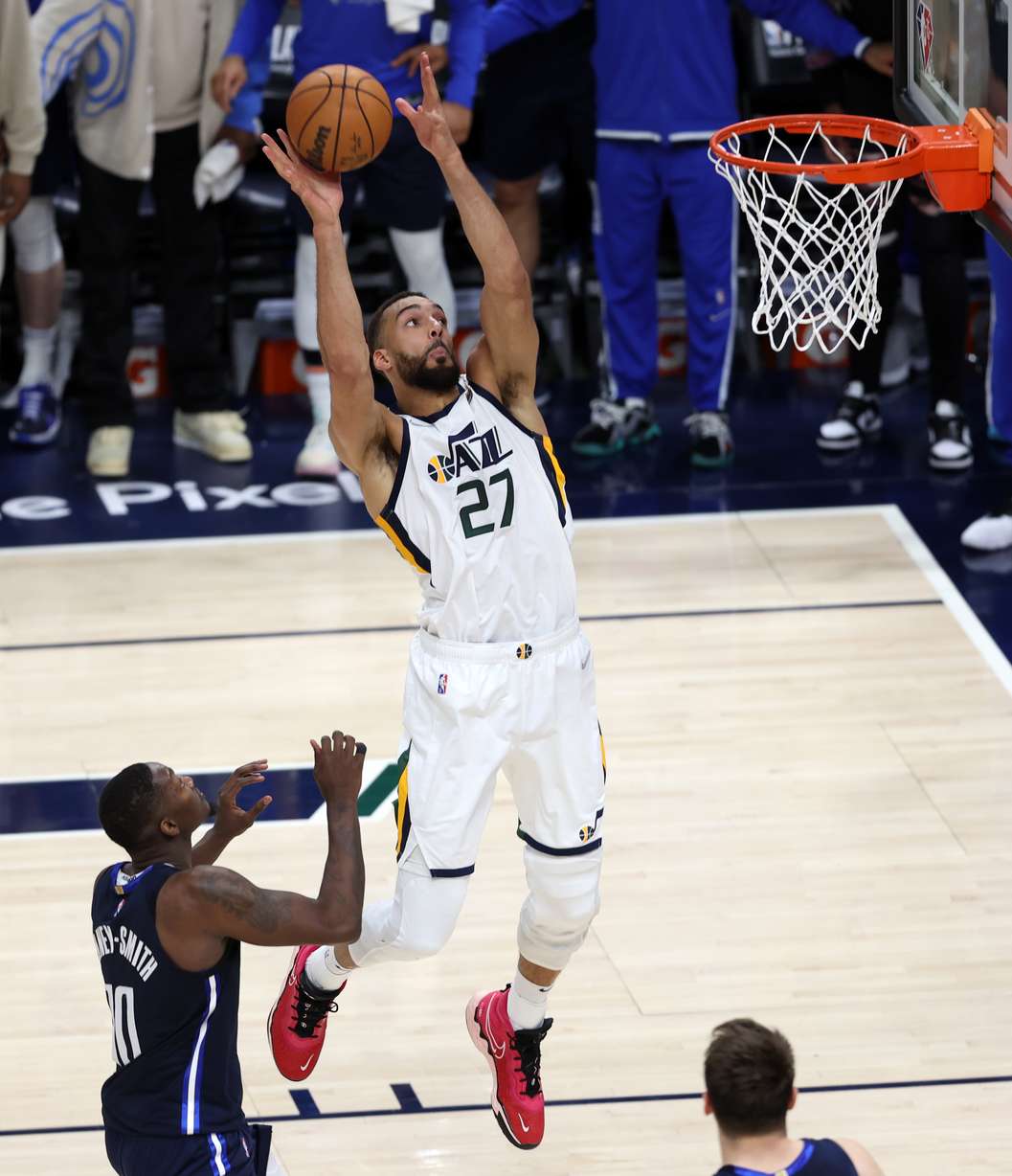 Utah Jazz center Rudy Gobert (27) catches an alley-oop pass from teammate Utah Jazz guard Donovan Mitchell (45) on his way in for a dunk over Dallas Mavericks forward Dorian Finney-Smith (10) as the Utah Jazz and the Dallas Mavericks play game four at Vivint Arena in Salt Lake City on Saturday, April 23, 2022. Utah won 100-99.
