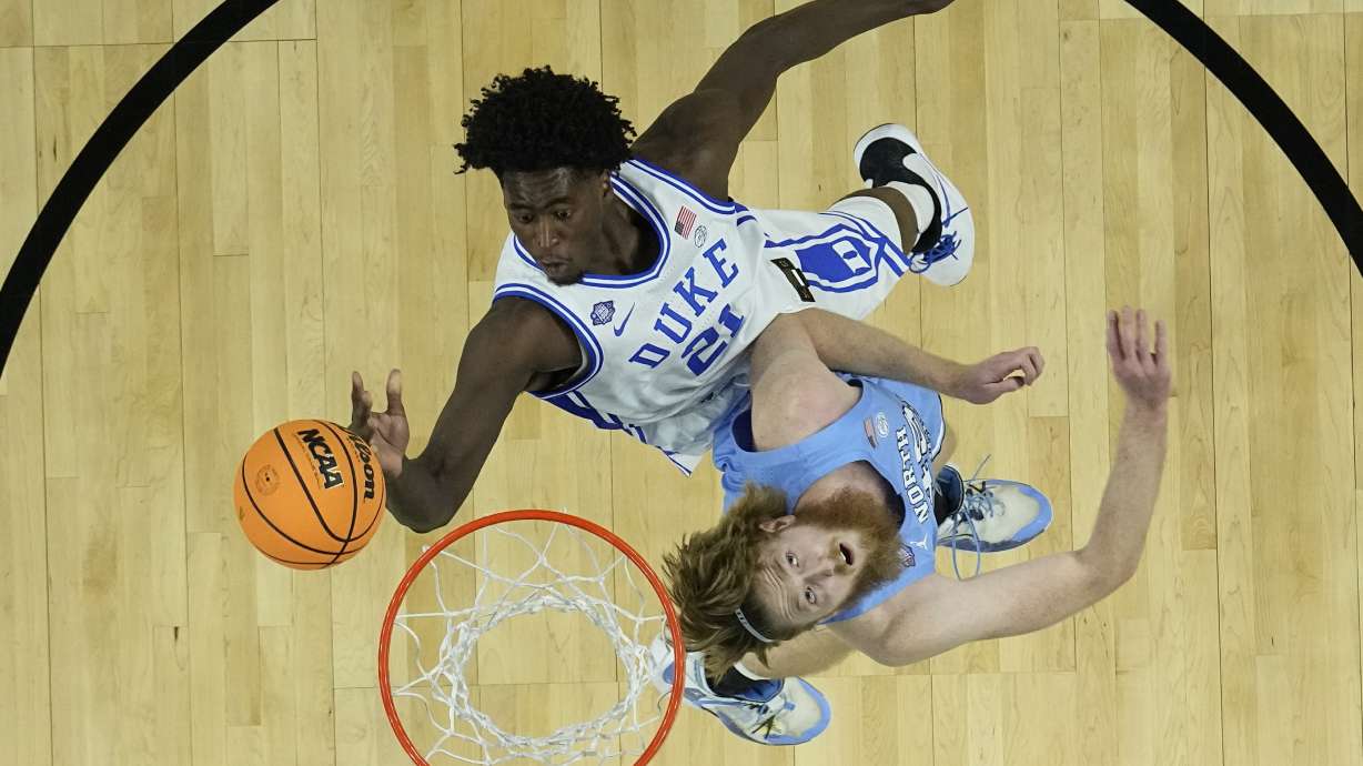 Duke's AJ Griffin (21) shoots over North Carolina's Brady Manek during the first half of a college basketball game in the semifinal round of the Men's Final Four NCAA tournament, Saturday, April 2, 2022, in New Orleans.