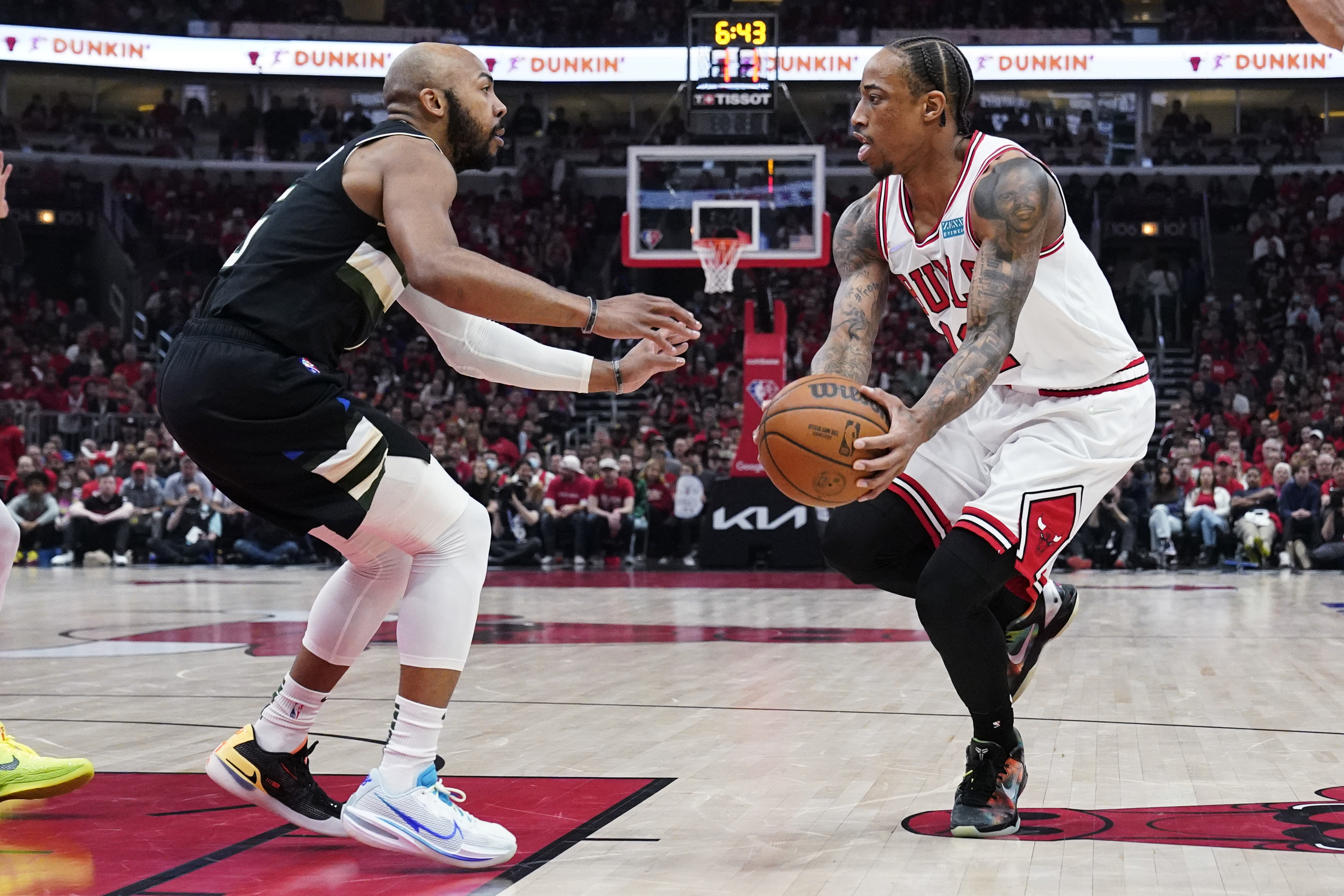 Chicago Bulls forward DeMar DeRozan, right, looks to pass against Milwaukee Bucks guard Jevon Carter during the first half of Game 4 of a first-round NBA basketball playoff series Sunday, April 24, 2022, in Chicago. 