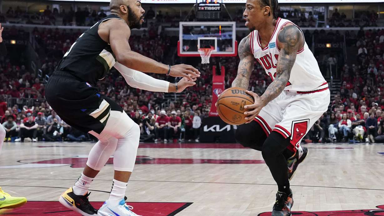 Chicago Bulls forward DeMar DeRozan, right, looks to pass against Milwaukee Bucks guard Jevon Carter during the first half of Game 4 of a first-round NBA basketball playoff series Sunday, April 24, 2022, in Chicago.