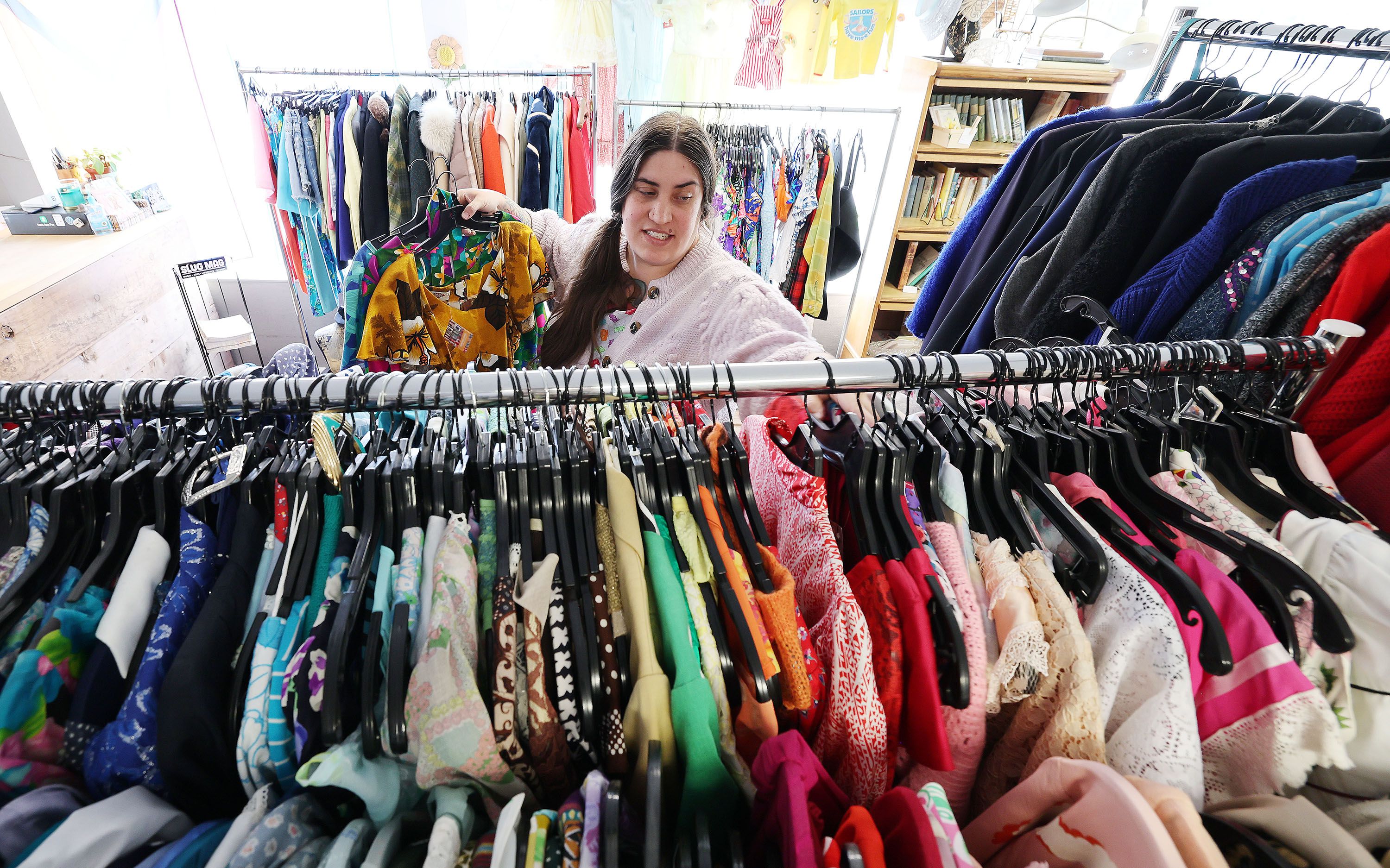 Copperhive Vintage owner Jacqueline Whitmore hangs vintage clothing at her store in Salt Lake City on April 14.