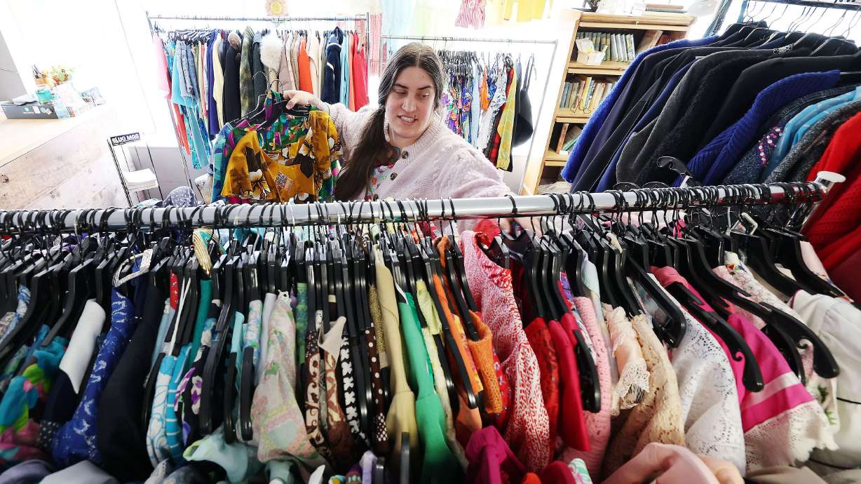 Copperhive Vintage owner Jacqueline Whitmore hangs vintage clothing at her store in Salt Lake City on April 14.