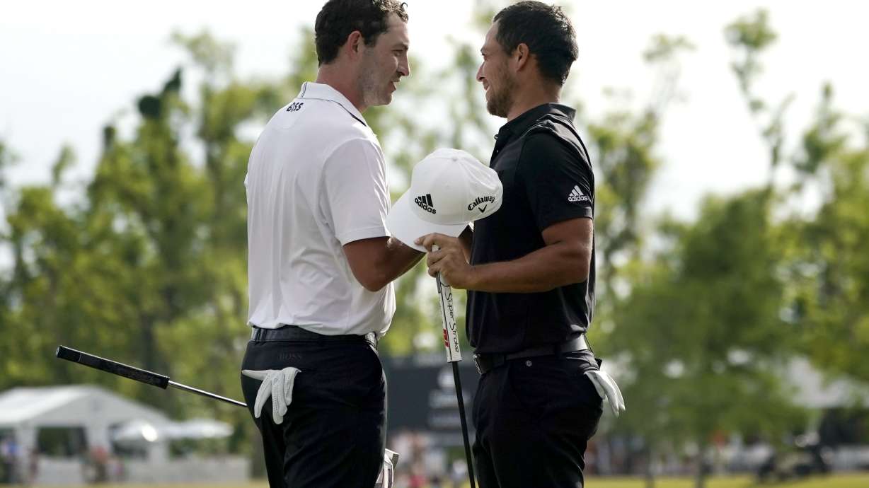Patrick Cantlay and his teammate Xander Schauffele, right, congratulate each other after their win in the PGA Zurich Classic golf tournament at TPC Louisiana in Avondale, La., Sunday, April 24, 2022.
