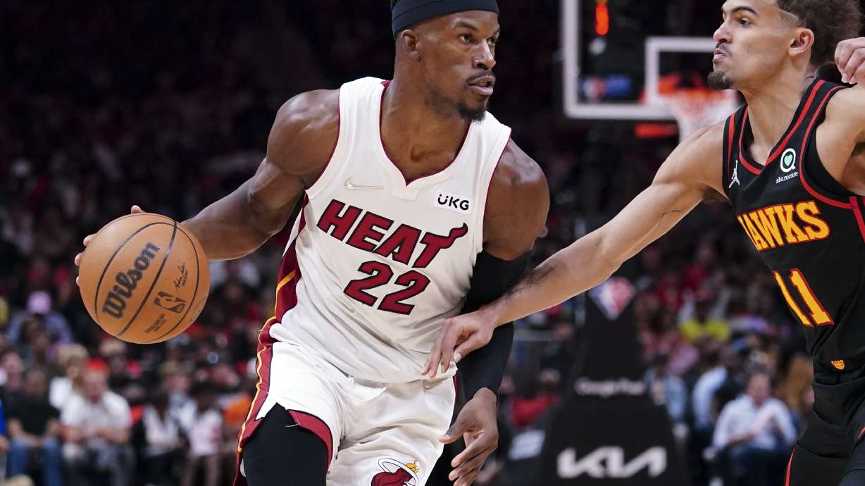 Miami Heat forward Jimmy Butler (22) drives against Atlanta Hawks guard Trae Young (11) in the first half of an NBA playoff basketball game Sunday, April 24, 2022, in Atlanta.