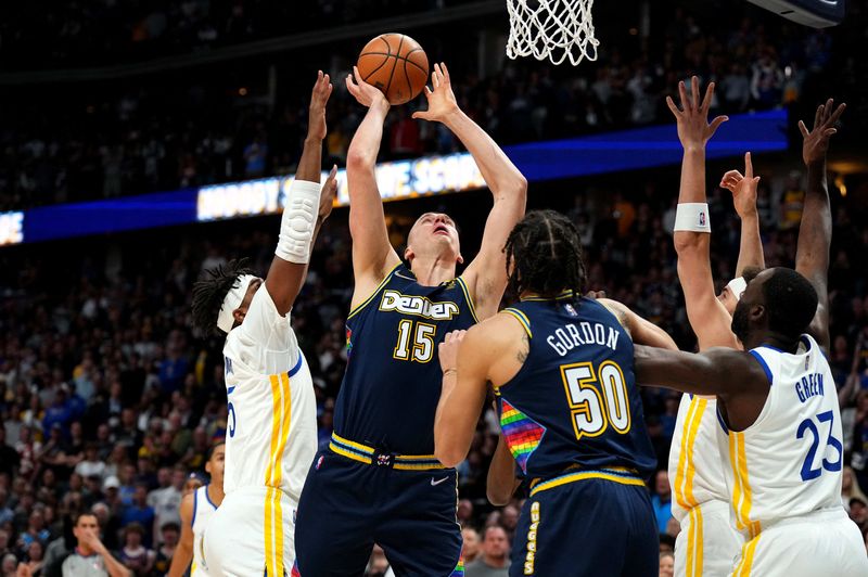 Apr 24, 2022; Denver, Colorado, USA; Denver Nuggets center Nikola Jokic (15) shoots past Golden State Warriors center Kevon Looney (5) in the first quarter of the first round for the 2022 NBA playoffs at Ball Arena.