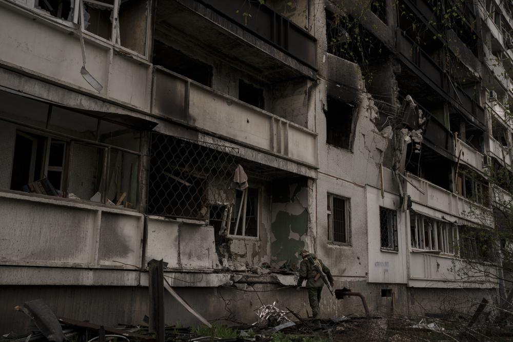 A Ukrainian serviceman inspects a heavily damaged apartment building after Russian bombardment in Kharkiv, Ukraine, Sunday. Russia unleashed a string of attacks against Ukrainian rail and fuel installations Monday, striking crucial infrastructure far from the front line of its eastern offensive.