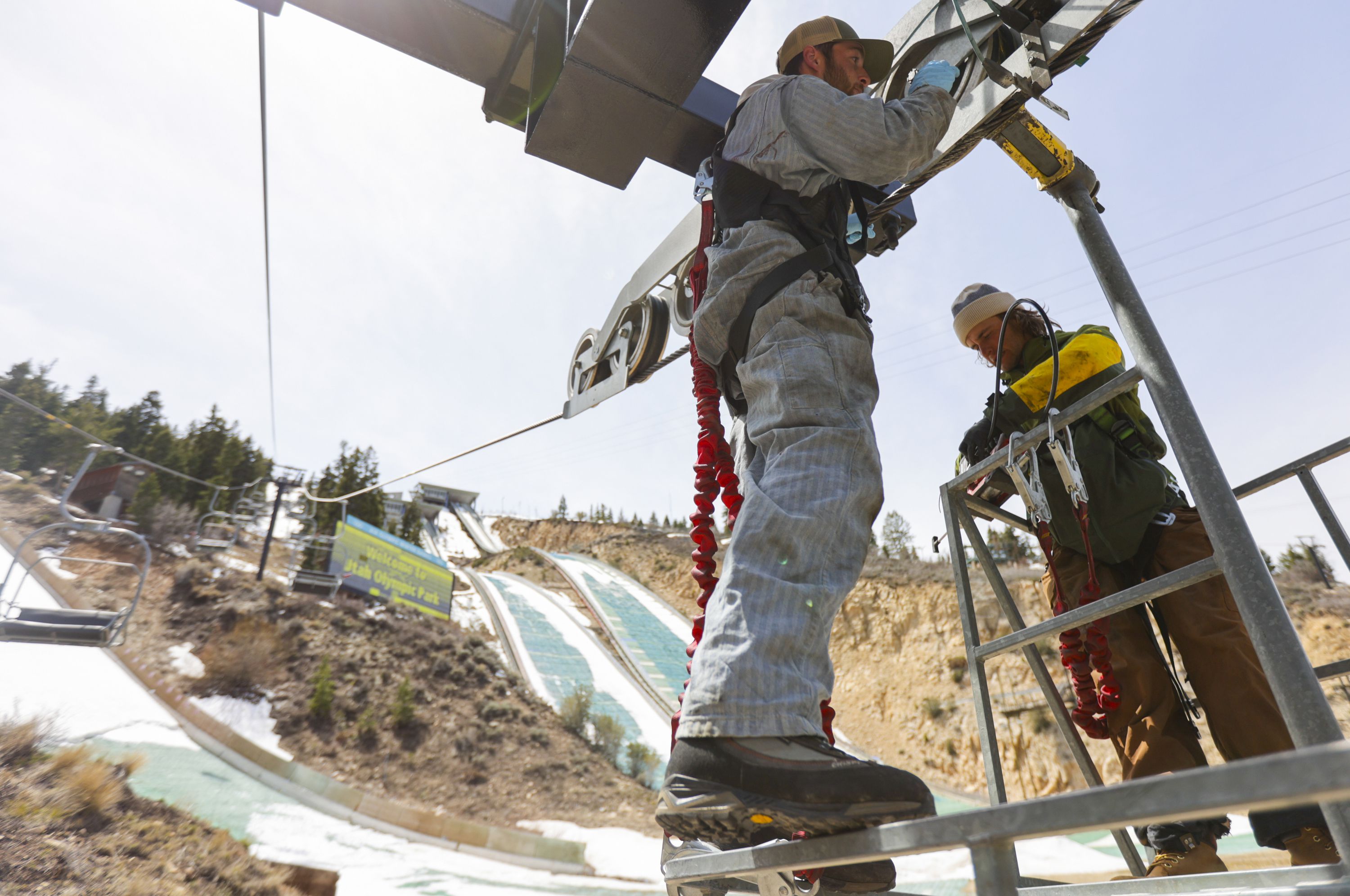 Lift operators Jack Gayton, left, and Ben Marmer, add grease to a wheel on the Nordic Chairlift at the Utah Olympic Park in Park City on April 25. The International Olympic Committee's trio of technical experts will inspect Utah's proposed 2030 or 2034 Winter Games venues this week as part of the bid process.