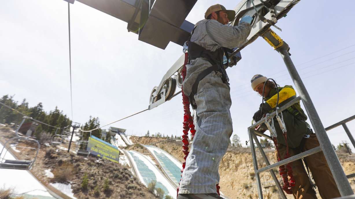 Lift operators Jack Gayton, left, and Ben Marmer, add grease to a wheel on the Nordic Chairlift at the Utah Olympic Park in Park City on April 25. The International Olympic Committee's trio of technical experts will inspect Utah's proposed 2030 or 2034 Winter Games venues this week as part of the bid process.