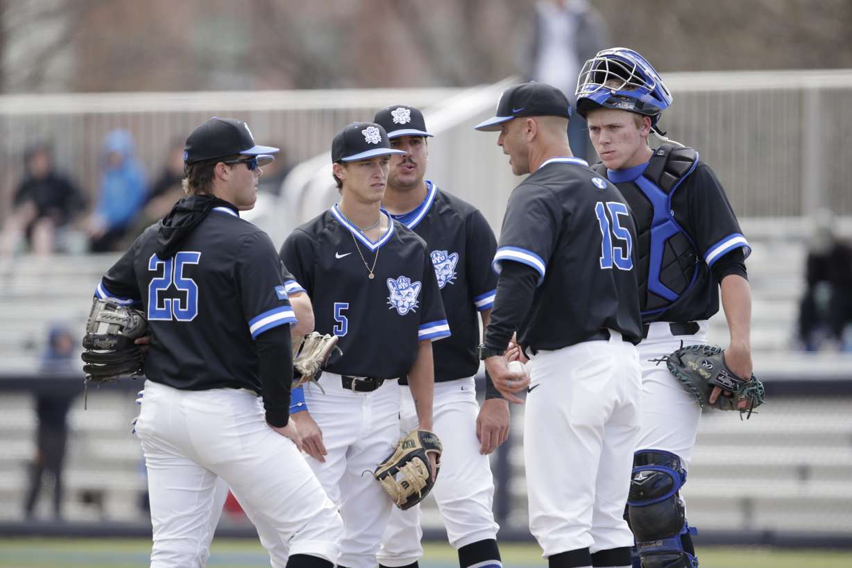 BYU baseball interim head coach Trent Pratt, right, talks middle infielder Ozzie Pratt, middle, catcher Collin Reuter, and first baseman Austin Deming (25) during a game against San Diego, Saturday, April 23, 2022 at Miller Park in Provo.