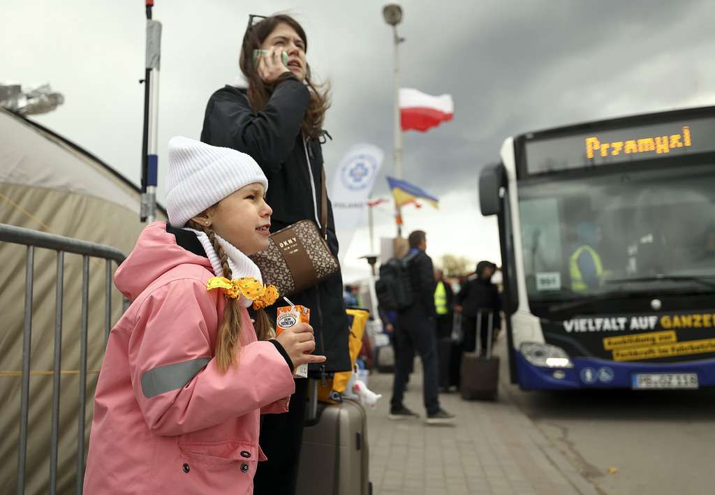 Ukrainian refugee Uliana Kozak, 6, winces from the cold as her mother Valerie Kozak makes a phone call after crossing the Polish/Ukrainian border in Medyka, Poland, on April 18. The mother and daughter fled Kyiv and are planning to go stay with relatives in Tampa, Fla.