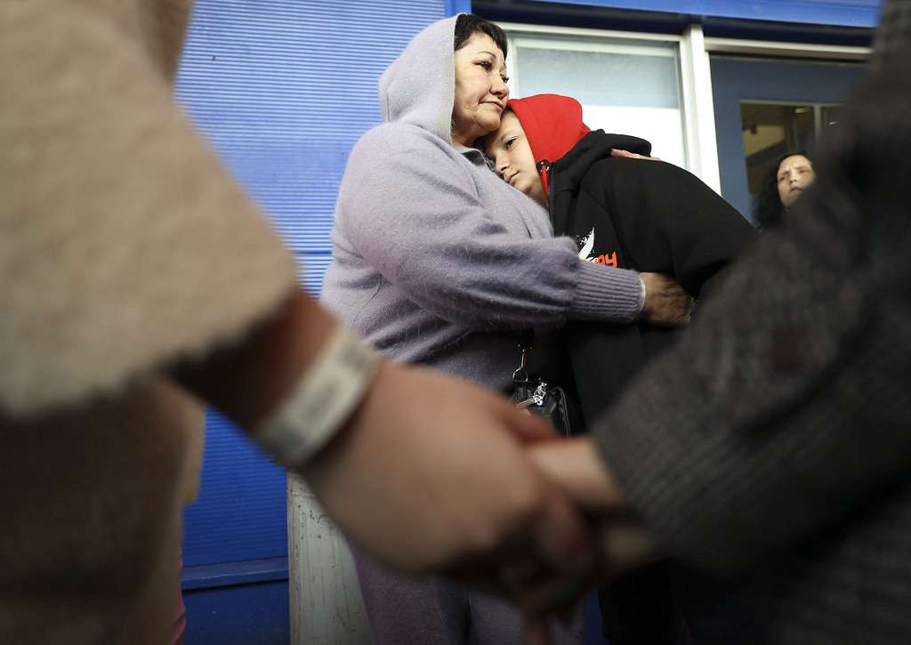 Ukrainian refugee Valentina Chukhno hugs her grandson Zhan as Chukhno’s daughter and granddaughter hold hands in the foreground outside of an old Tesco store that is being used to house refugees in Przemysl, Poland, on Thursday. Chukhno’s other daughter, who is Zhan’s mother, is fighting in the war against Russia.