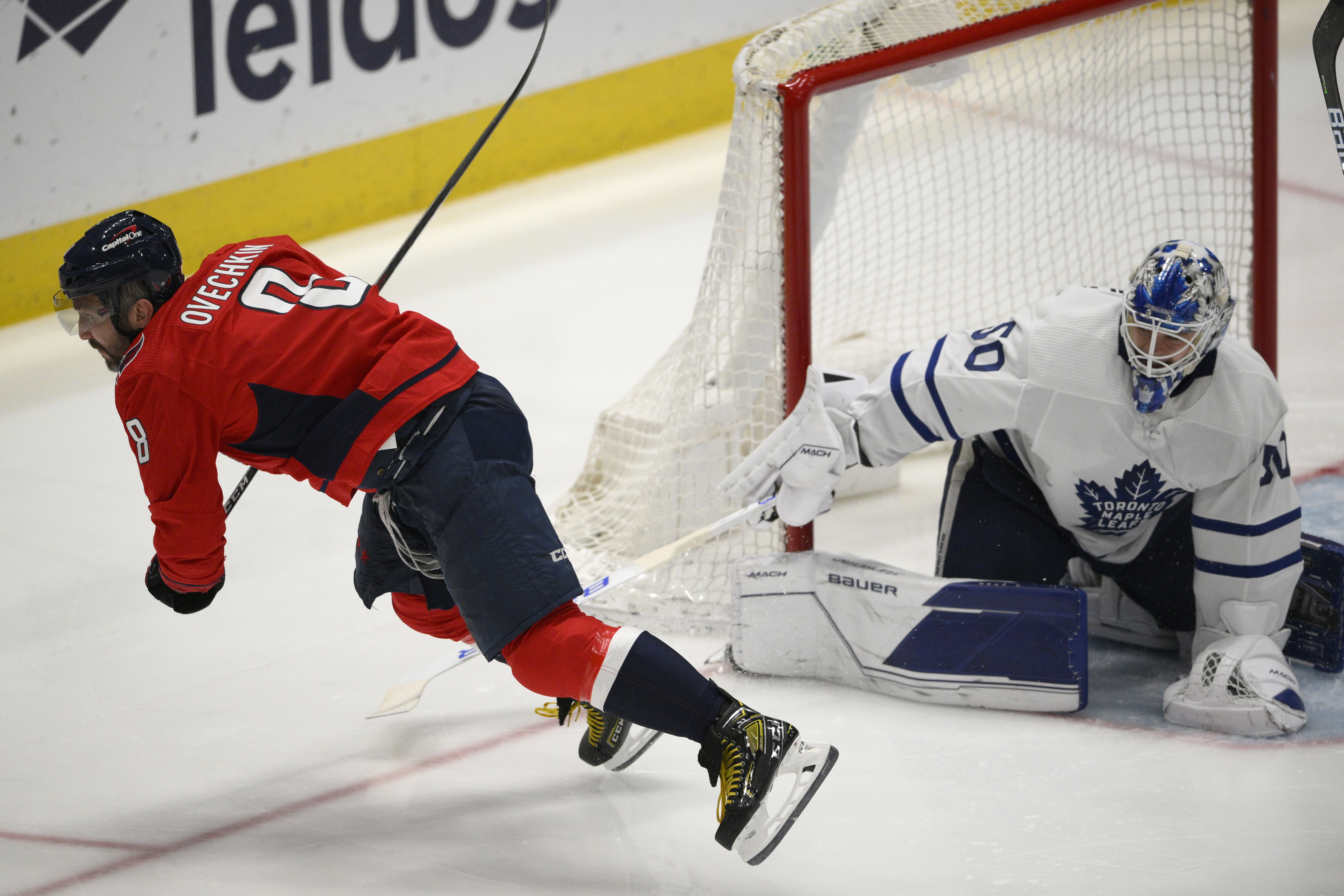 Washington Capitals left wing Alex Ovechkin (8) is tripped by Toronto Maple Leafs goaltender Erik Kallgren (50) during the third period of an NHL hockey game, Sunday, April 24, 2022, in Washington. Ovechkin left with an injury after the play. 