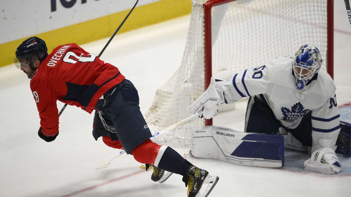 Washington Capitals left wing Alex Ovechkin (8) is tripped by Toronto Maple Leafs goaltender Erik Kallgren (50) during the third period of an NHL hockey game, Sunday, April 24, 2022, in Washington. Ovechkin left with an injury after the play.