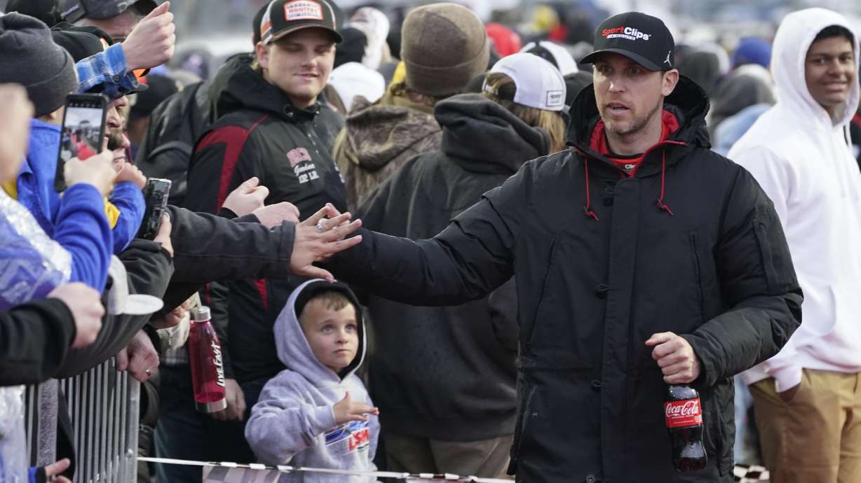 Denny Hamlin, righ, greets fans before the NASCAR Cup Series auto race at Martinsville Speedway on Saturday, April 9, 2022, in Martinsville, Va.