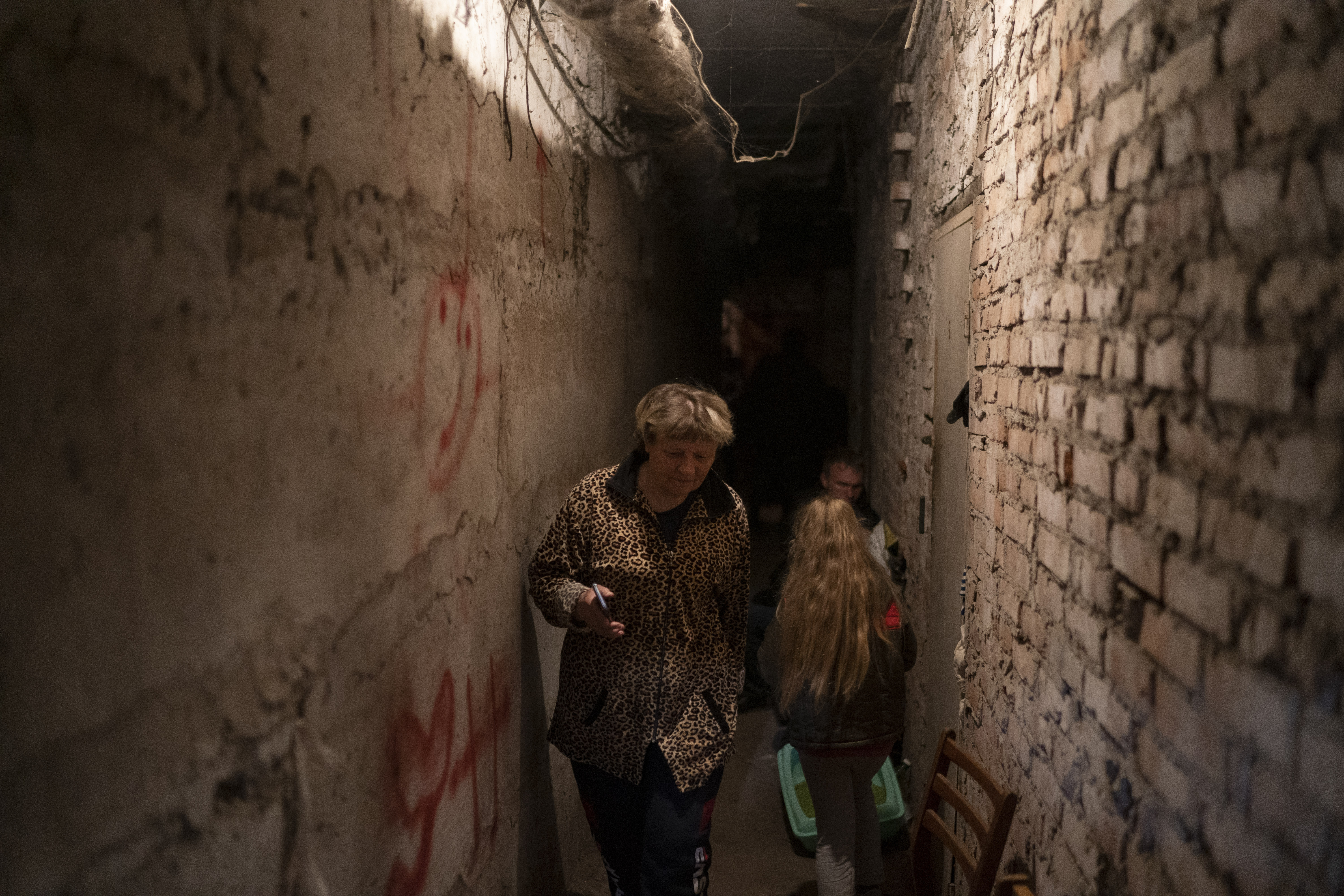 Helena walks inside the basement of a residential building during a Russian attack in Lyman, Ukraine, Tuesday. The 60-year-old woman says it's a very difficult moment.