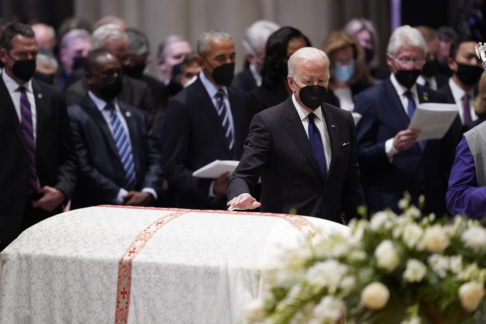 President Joe Biden places his hand on the casket of former Secretary of State Madeleine Albright during the funeral service at the Washington National Cathedral, Wednesday in Washington. 

