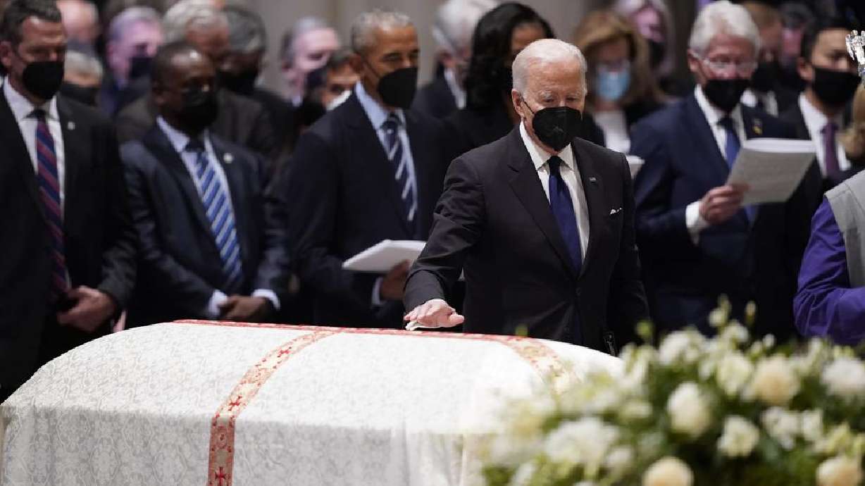 President Joe Biden places his hand on the casket of former Secretary of State Madeleine Albright during the funeral service at the Washington National Cathedral, Wednesday in Washington.