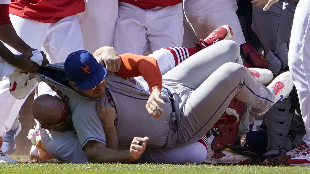 New York Mets' Pete Alonso is taken to the ground by St. Louis Cardinals first base coach Stubby Clapp, rear, as benches clear during a scuffle in the eighth inning of a baseball game Wednesday, April 27, 2022, in St. Louis. Clapp was ejected from the game.