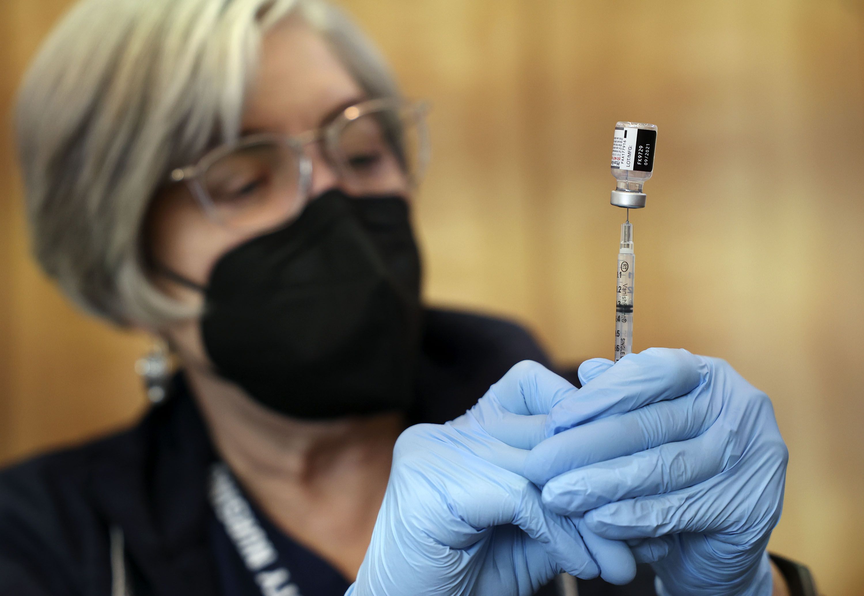 Community Nursing Services Janie Wilson prepares a syringe of the Pfizer-BioNTech COVID-19 vaccine at the Olpin Student Union at the University of Utah in Salt Lake City on Jan. 20. Dr. Anthony Fauci says we are out of the "pandemic phase," but COVID-19 isn't going away.