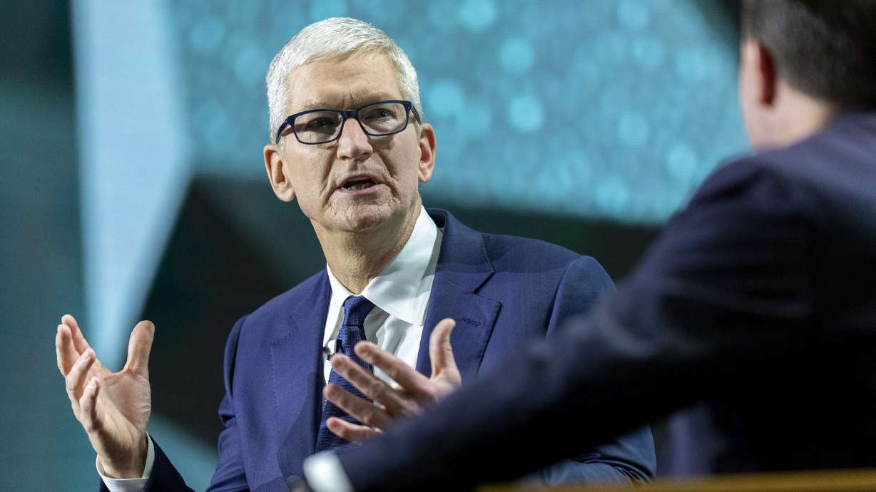 Apple CEO Tim Cook, left, talks with Sen. Mike Lee, R-Utah, during the Silicon Slopes Summit at the Salt Palace in Salt Lake City on Oct. 13, 2021. A new report finds median pay for top CEOs was up 31% last year to $20 million.