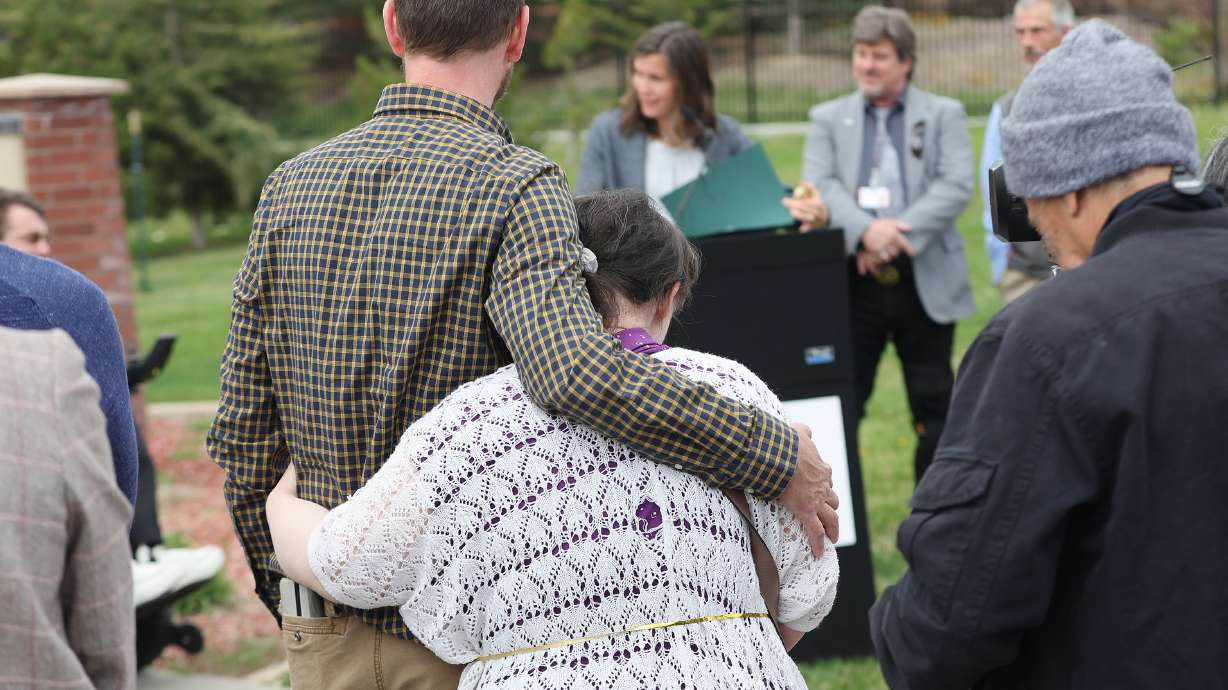Vard McGuire, with the Disability Law Center, hugs his sister, Mindy McGuire, as Salt Lake City Mayor Erin Mendenhall reads a proclamation about Fair Housing Month and the need for accessibility in housing at a press conference in Salt Lake City on Wednesday.