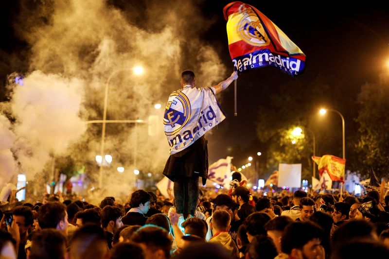 FILE PHOTO: Soccer Football - Real Madrid fans watch the Champions League Final - Madrid, Spain - May 27, 2018 Real Madrid fans celebrate near the Cibeles fountain in central Madrid after their team won the Champions League