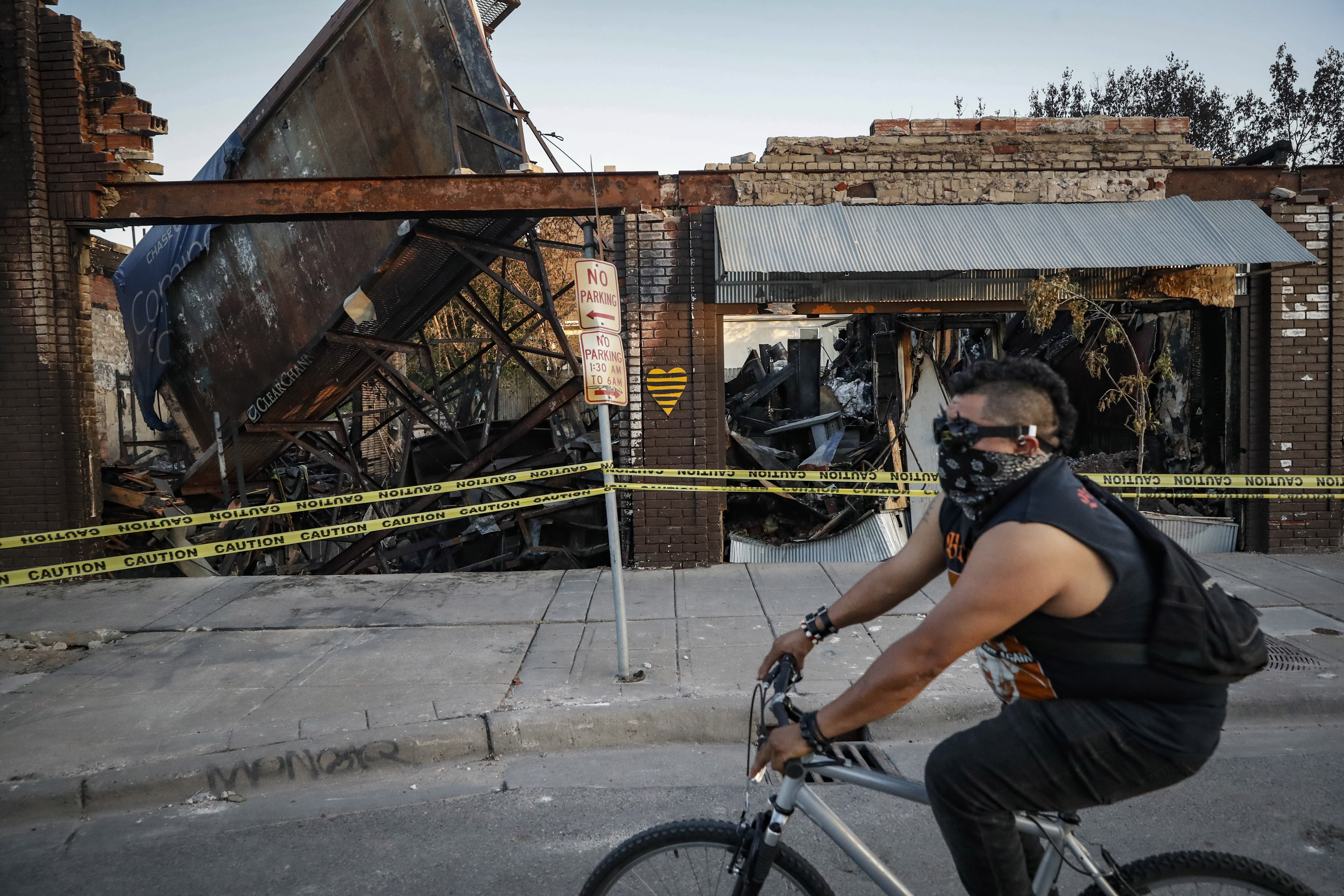 A cyclist passes burned-out businesses along East Lake Street on June 1, 2020, that were destroyed in protests two nights earlier in Minneapolis. The former Minneapolis police officer found guilty of murder in the killing of George Floyd has appealed his conviction, saying among other things that the jury was intimidated by ongoing sometimes violent protests and prejudiced by excessive pre-trial publicity.