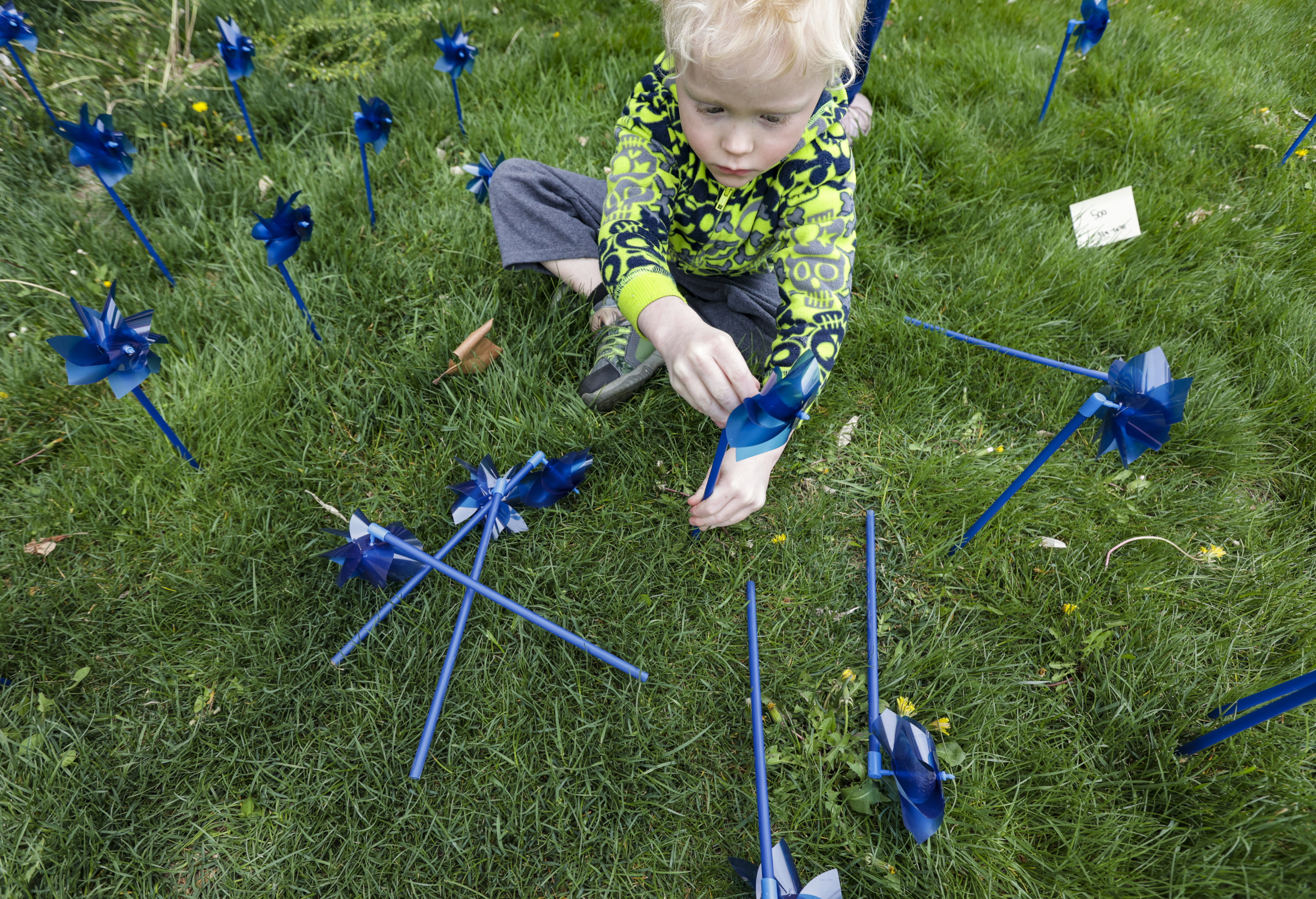 Braxton Leyer, 5, plants blue pinwheels in honor of victims of child abuse at the Salt Lake County Government Center in Salt Lake City on Thursday.