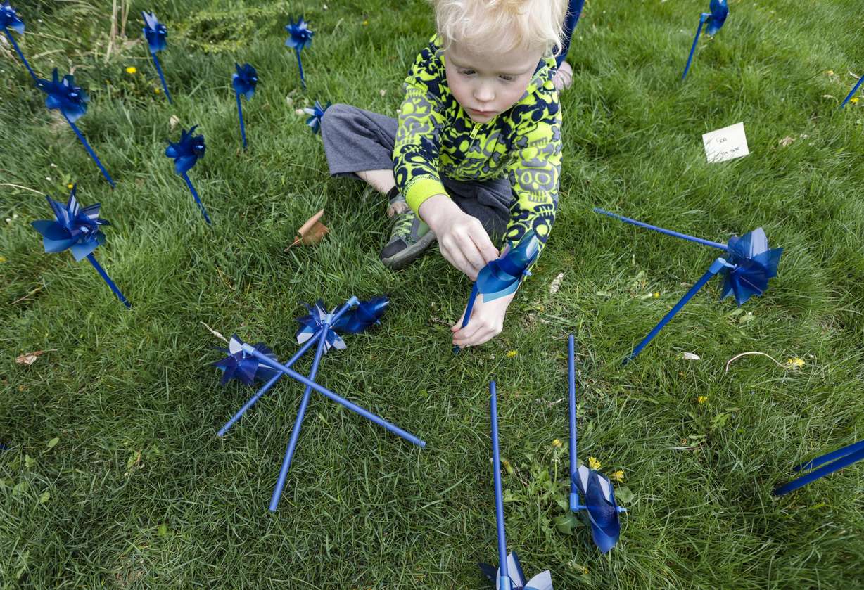 Braxton Leyer, 5, plants blue pinwheels in honor of victims of child abuse at the Salt Lake County Government Center in Salt Lake City on Thursday.