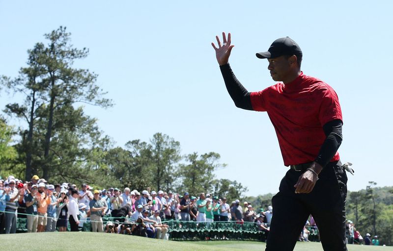 FILE PHOTO: Golf - The Masters - Augusta National Golf Club - Augusta, Georgia, U.S. - April 10, 2022 Tiger Woods of the U.S. waves to patrons on the 18th after finishing his final round