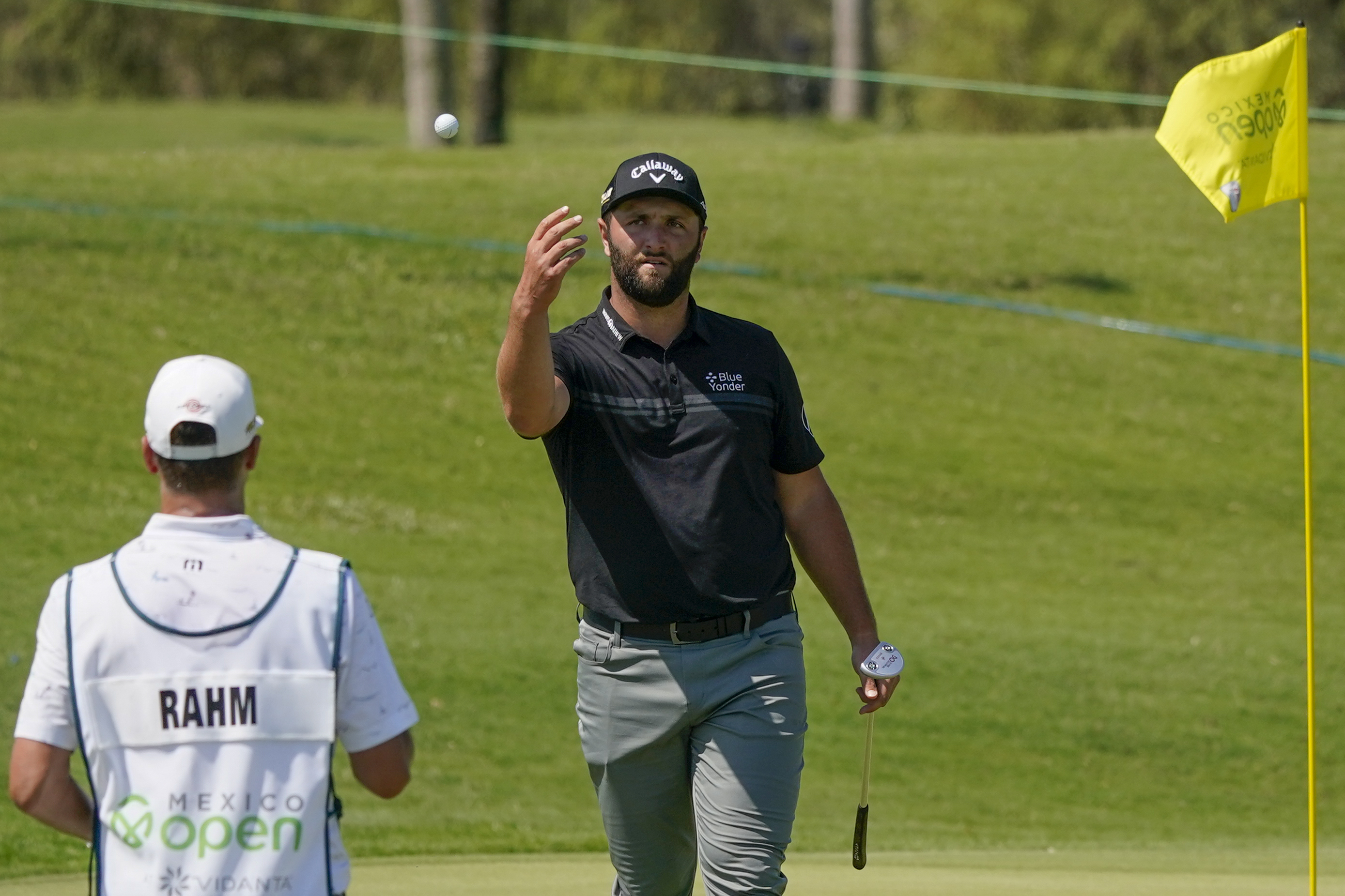 Jon Rahm of Spain throws a ball to his caddie on the fourth hole during the first round of the Mexico Open at Vidanta in Puerto Vallarta, Mexico, Thursday, April 28, 2022.