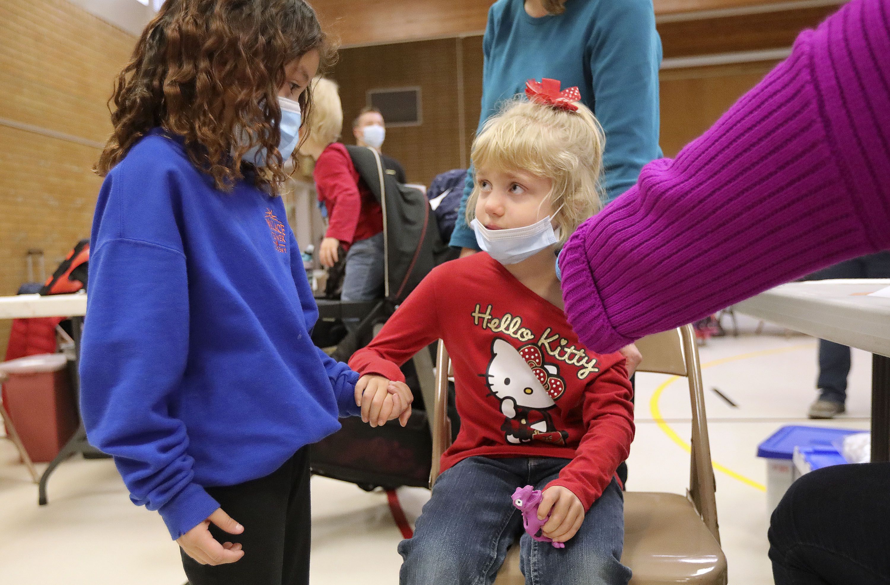 Abygail Redmond, 6, holds Tabitha Mann’s hand as Mann, 6, gets her COVID-19 vaccination at Hillsdale Elementary School in West Valley City on Nov. 8, 2021. Redmond offered Mann her squishy to make the shot easier. Mann also comforted Redmond after Redmon’s shot. The two girls didn’t know each other.