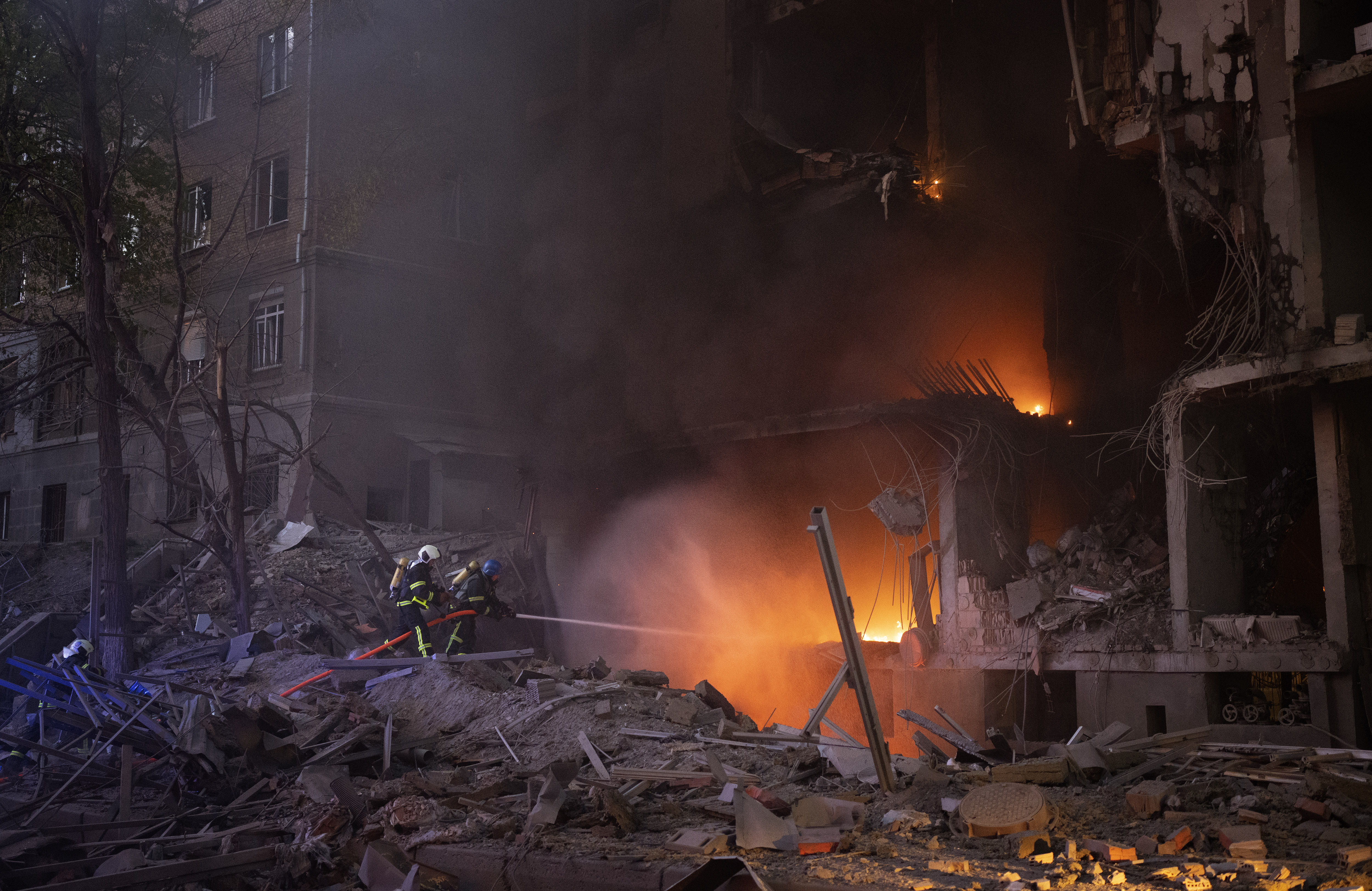 Firefighters try to put out a fire following an explosion in Kyiv, Ukraine, on Thursday. A 22-year-old former U.S. Marine was killed alongside Ukrainian forces in the war with Russia, his relatives told news outlets in what’s the first known death of an American citizen fighting in Ukraine.