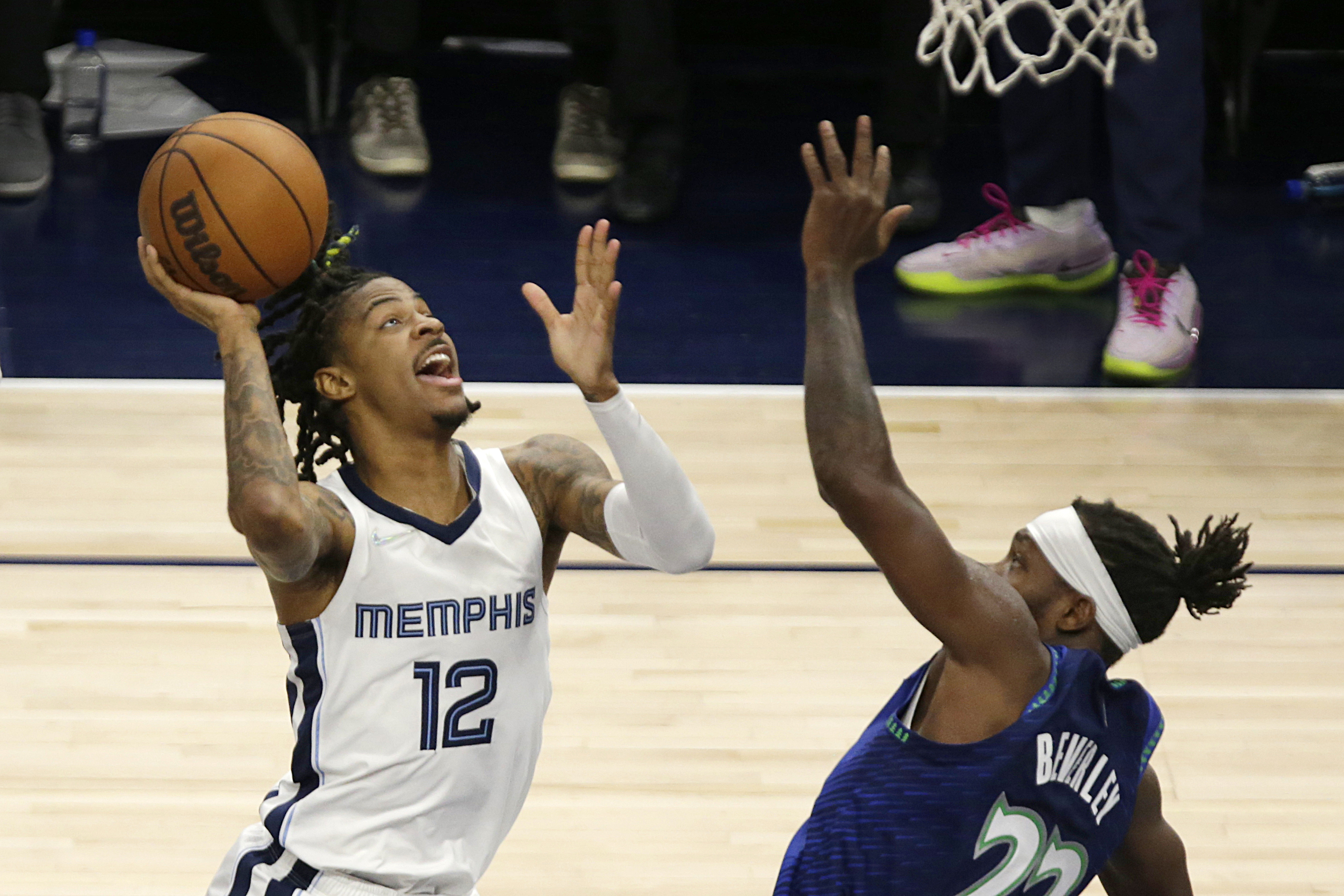 Memphis Grizzlies guard Ja Morant (12) shoots against Minnesota Timberwolves guard Patrick Beverley (22) in the first half in Game 6 of an NBA basketball first-round playoff series Friday, April 29, 2022, in Minneapolis. 