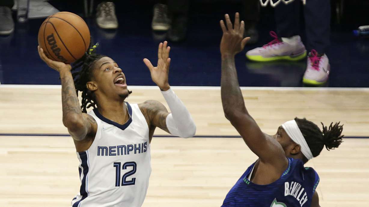 Memphis Grizzlies guard Ja Morant (12) shoots against Minnesota Timberwolves guard Patrick Beverley (22) in the first half in Game 6 of an NBA basketball first-round playoff series Friday, April 29, 2022, in Minneapolis.