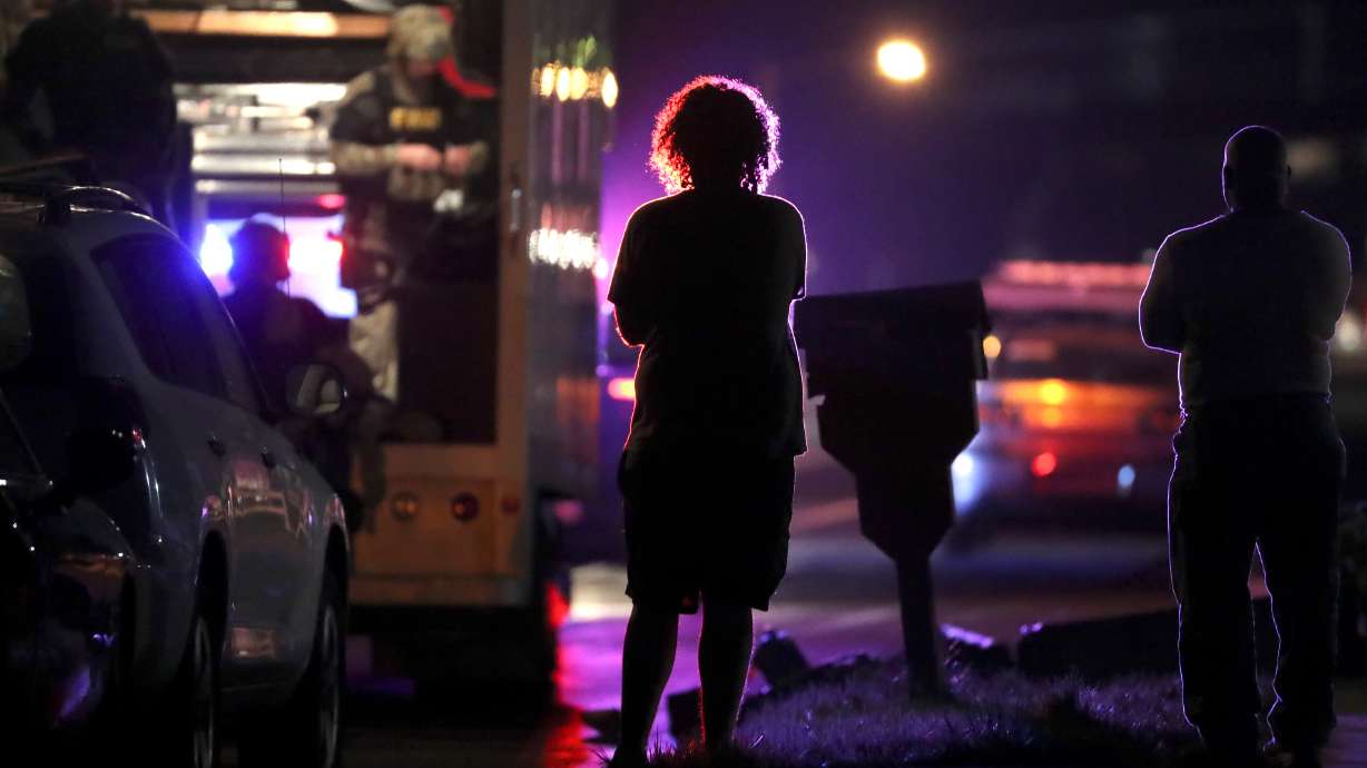 People watch SWAT respond to a stand-off in Riverdale, on Friday.