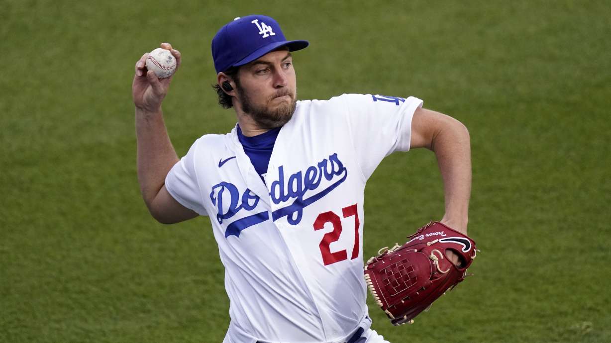 FILE - Los Angeles Dodgers starting pitcher Trevor Bauer warms up prior to a baseball game against the Colorado Rockies, April 13, 2021, in Los Angeles. Bauer was suspended Friday, April 29, 2022, for two full seasons without pay by Major League Baseball for violating the league's domestic violence and sexual assault policy, which he denies.