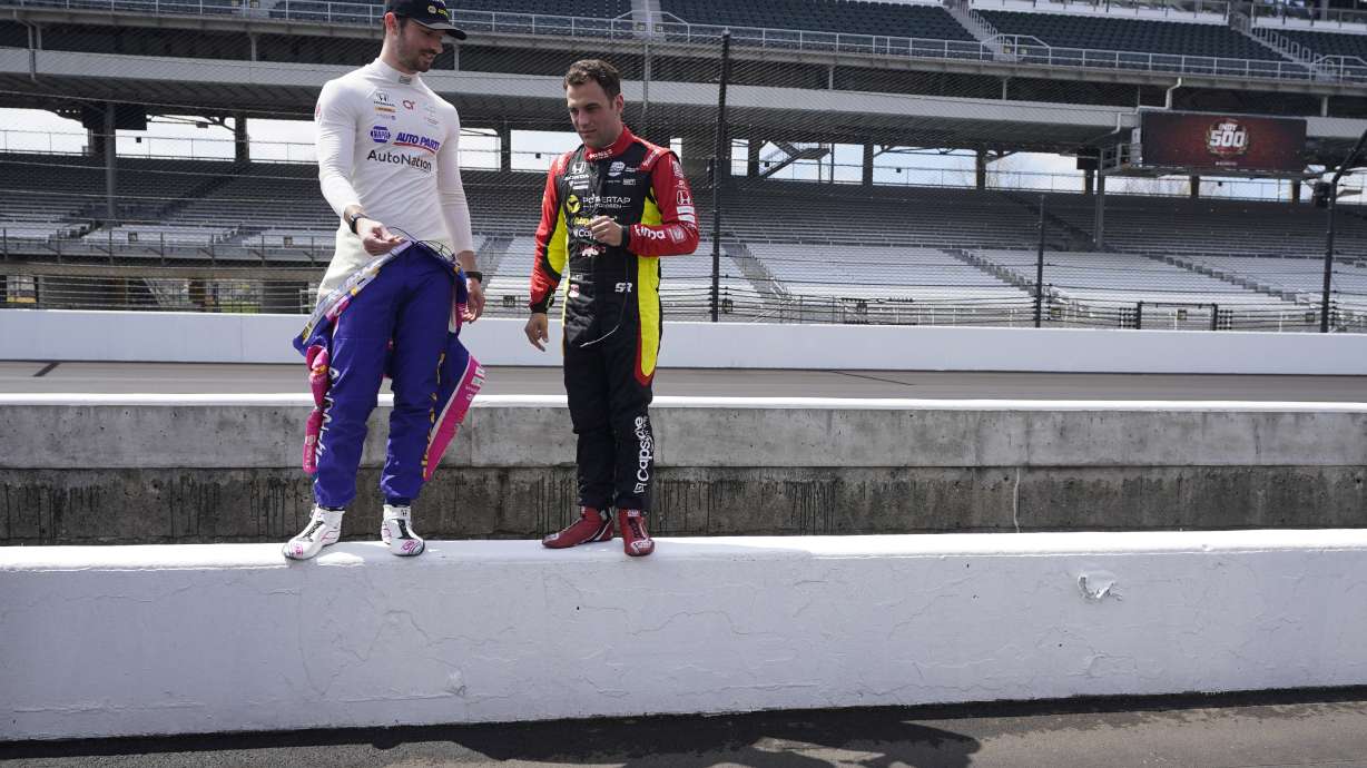 Alexander Rossi, left, and Delvin Defrancesco look at pit lane before testing at Indianapolis Motor Speedway, Thursday, April 21, 2022, in Indianapolis.