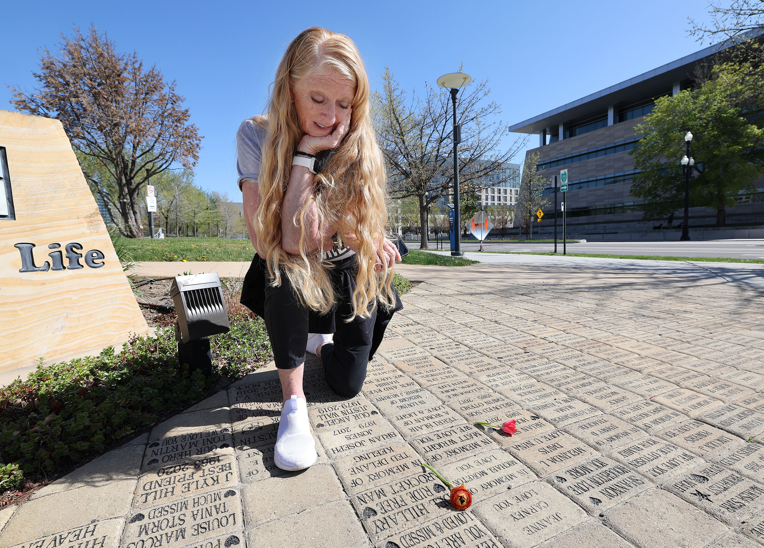 Nicole' Hillary leaves a flower on her husband and donor Del Hillary’s donor brick during National Donate Life Month and Donor Remembrance Day at the Celebration of Life Monument in Salt Lake City on Saturday.
