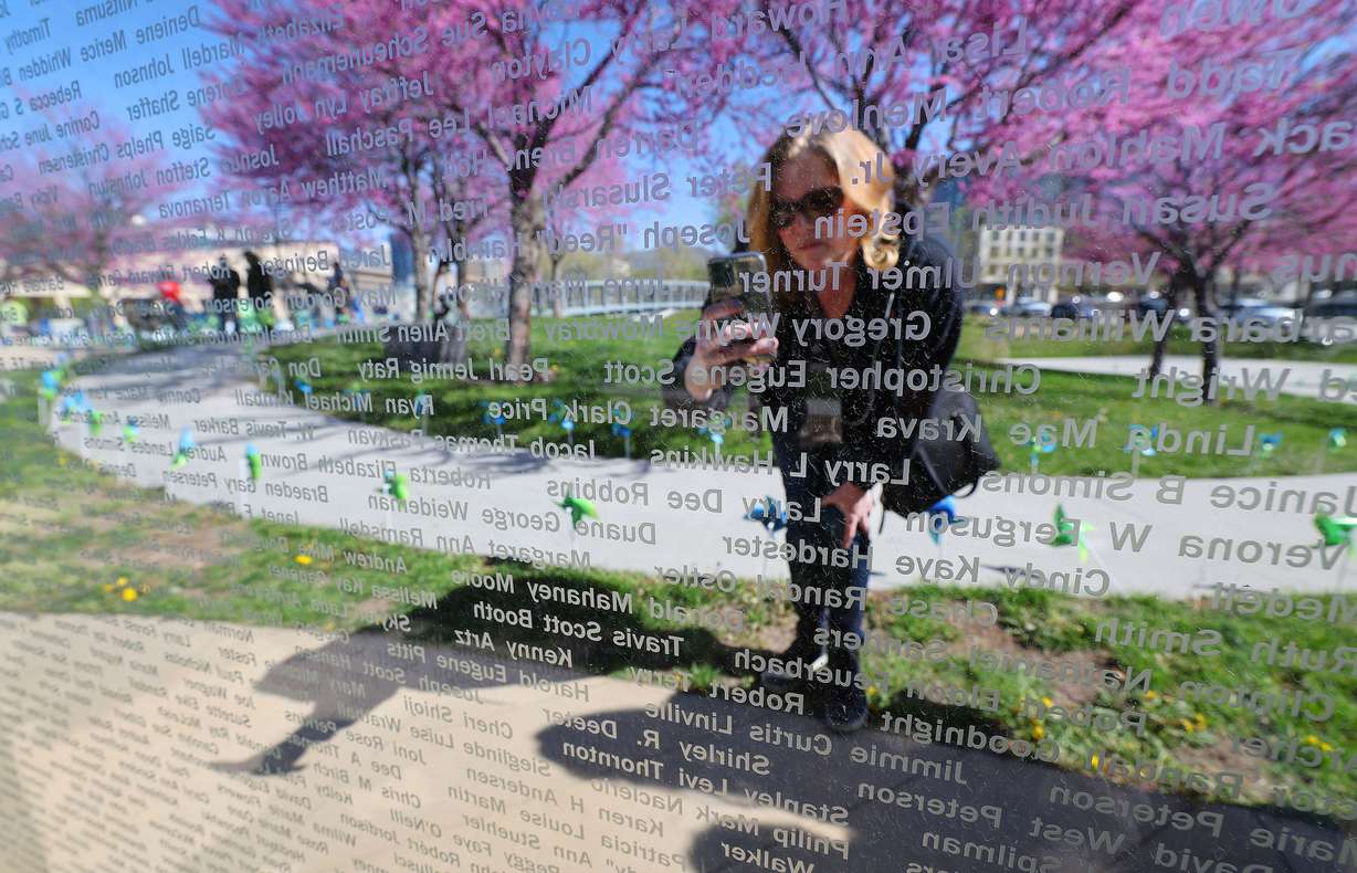 Annie Ableman takes a photo of her sister's name and donor Melissa Capener during National Donate Life Month and Donor Remembrance Day at the Celebration of Life Monument in Salt Lake City on Saturday.