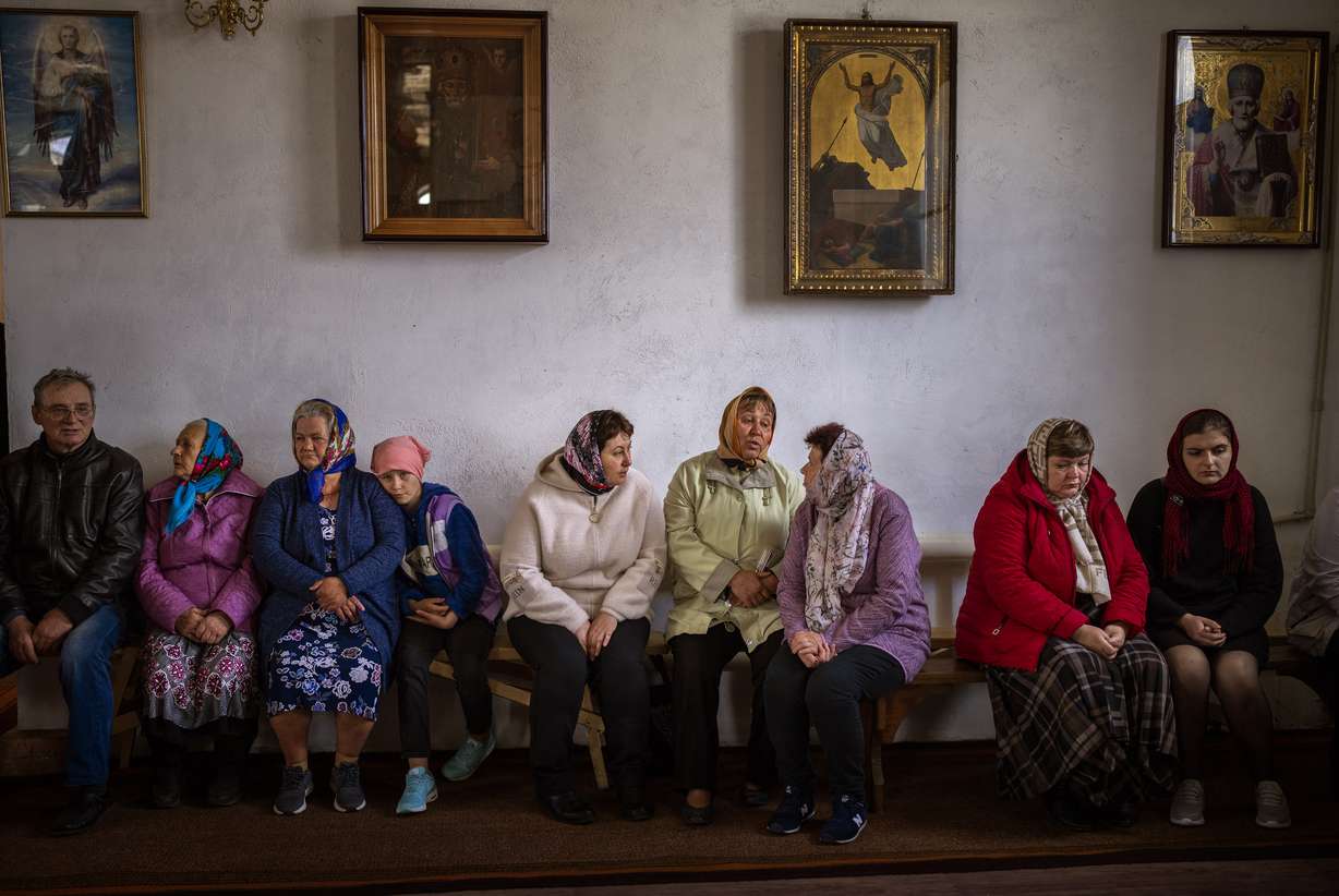 Ukraine women wait for the start of a religious service to commemorate the fallen during the Russian occupation in Zdvyzhivka, on the outskirts of Kyiv, on Saturday.
