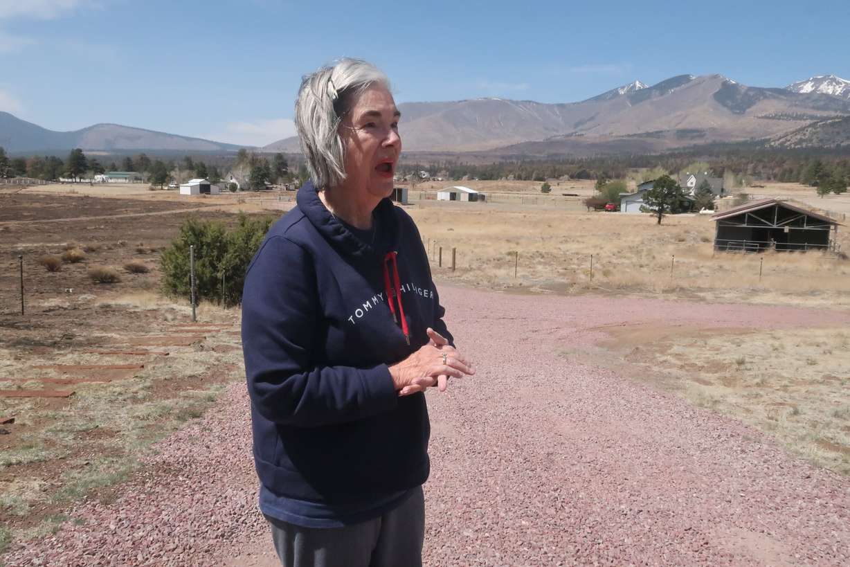 Harriet Young stands outside her home on the outskirts of Flagstaff, Ariz., Thursday. A massive wildfire that started Easter Sunday burned about 30 square miles and more than a dozen homes, hopscotching across the parched landscape.