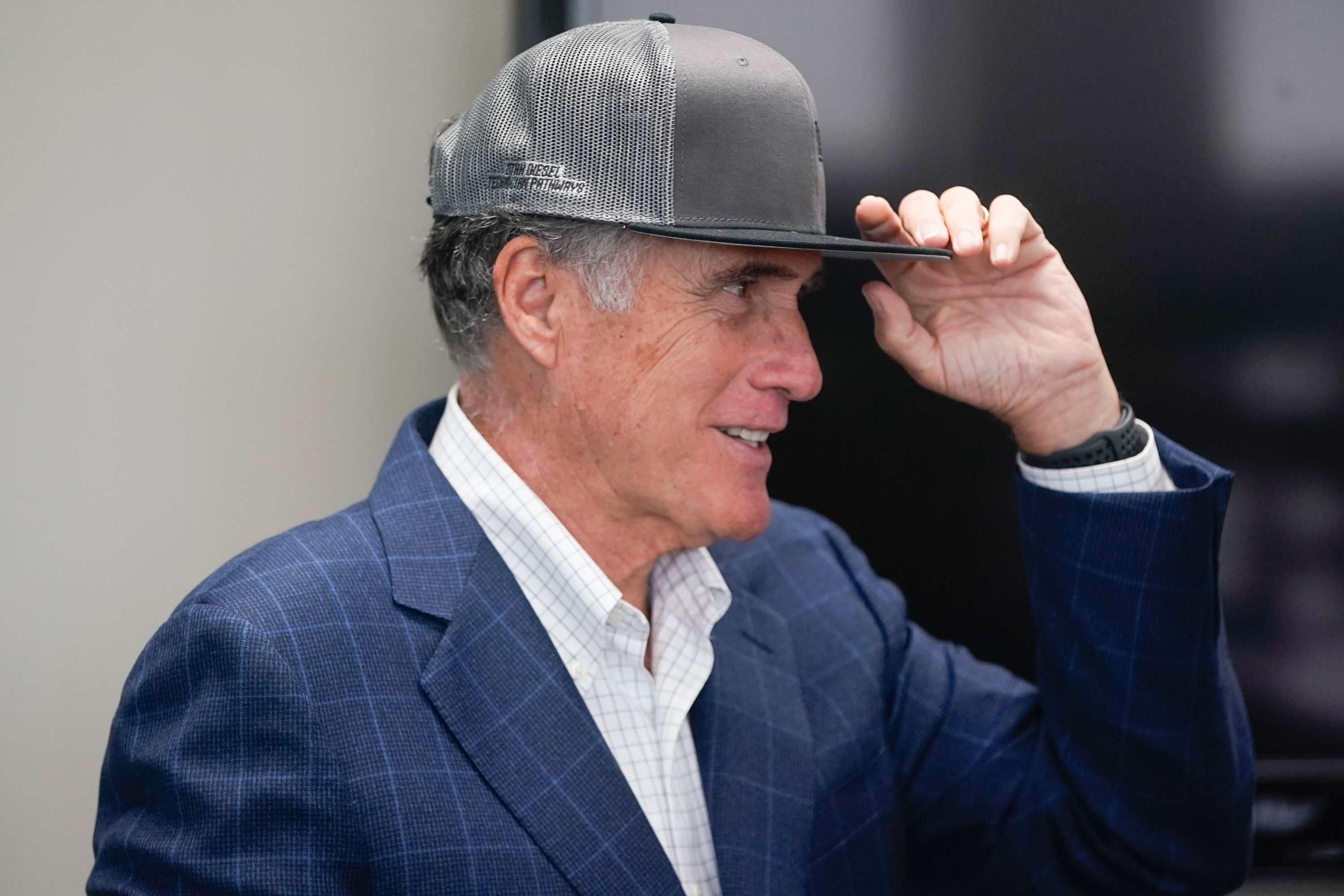 Sen. Mitt Romney, R-Utah, adjusts a hat that he was given after a tour of Kenworth Sales in West Valley City on Nov. 12, 2021. Romney reportedly wears a hat when vacationing in Florida to avoid unwanted attention.