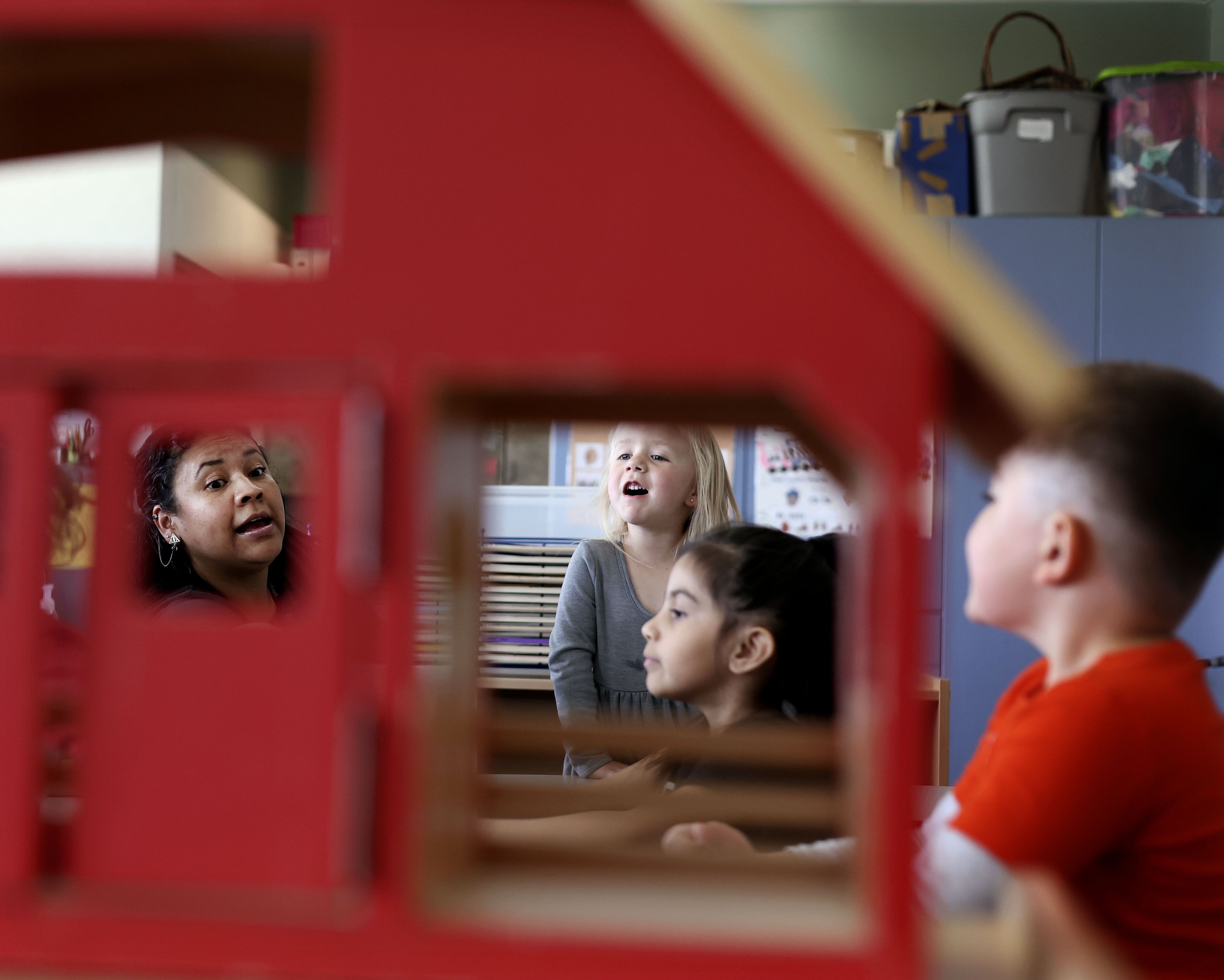 Preschool paraprofessional Ana Suastequi, left, plays with students at Sandy Elementary on April 27.