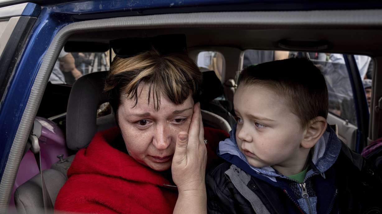 Natalia Pototska, 43, cries as her grandson Matviy looks on in a car at a center for displaced people in Zaporizhzhia, Ukraine, Monday. Ukrainian fighters say Russian forces began storming a sprawling steel plant in the besieged port city of Mariupol on Tuesday.