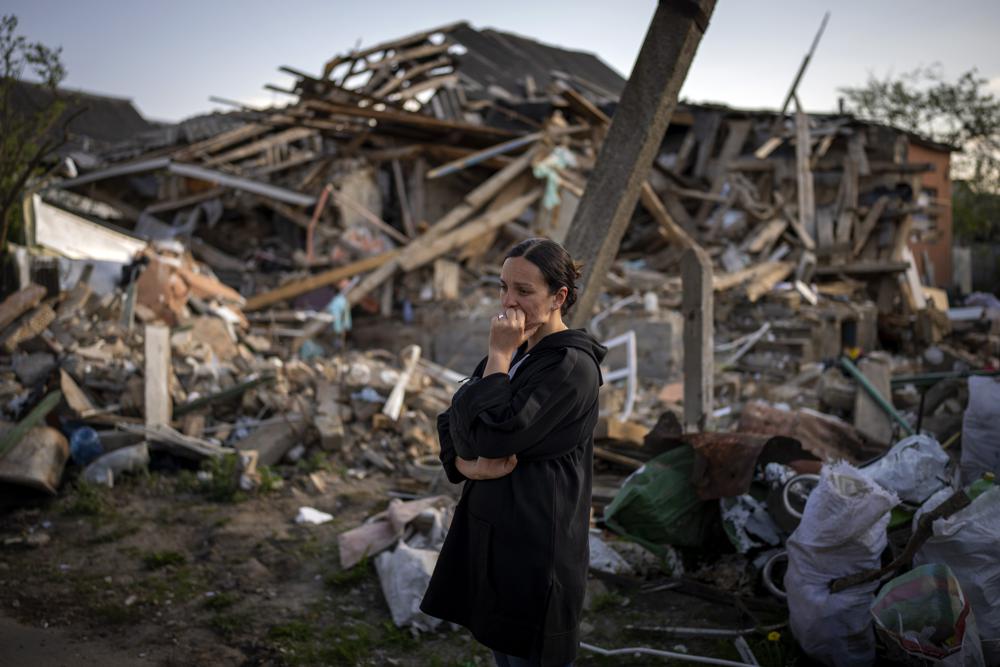Anna Shevchenko, 35, reacts next to her home in Irpin, near Kyiv, Tuesday. The house, built by Shevchenko's grandparents, was nearly completely destroyed by bombing in late March during the Russian invasion of Ukraine.