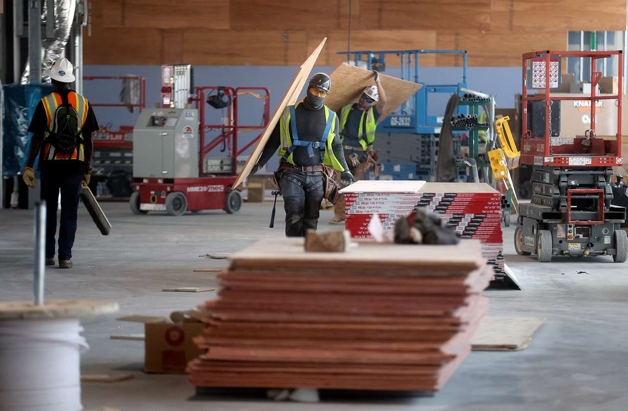 Construction crews carry plywood through Concourse A East at the new Salt Lake City International Airport in Salt Lake City, on Tuesday. The concourse is projected to have four gates open in the spring of 2023 and 18 gates open in the fall of 2023.