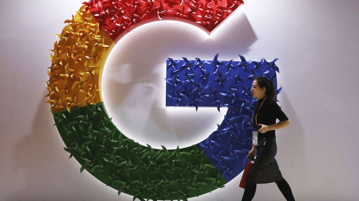 A woman walks past the logo for Google at the China International Import Expo in Shanghai on Nov. 5, 2018. Google said April 29 it will let people request that additional types of information such as personal contact information like phone numbers, email and physical addresses be removed from search results.