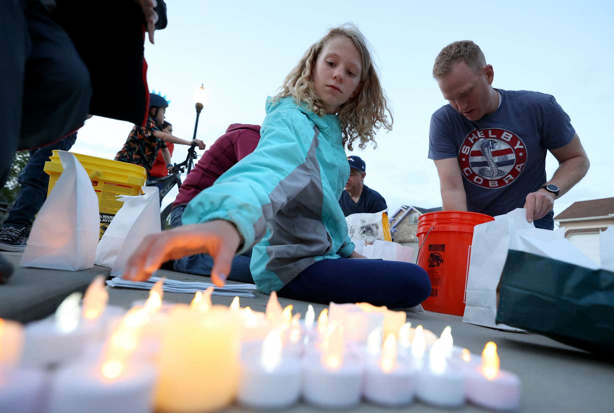 Lydia Johansen helps make luminary bags in honor of Eli Mitchell, a 13-year-old who died after being hit while riding his bike, in West Jordan on Monday, May 2, 2022.